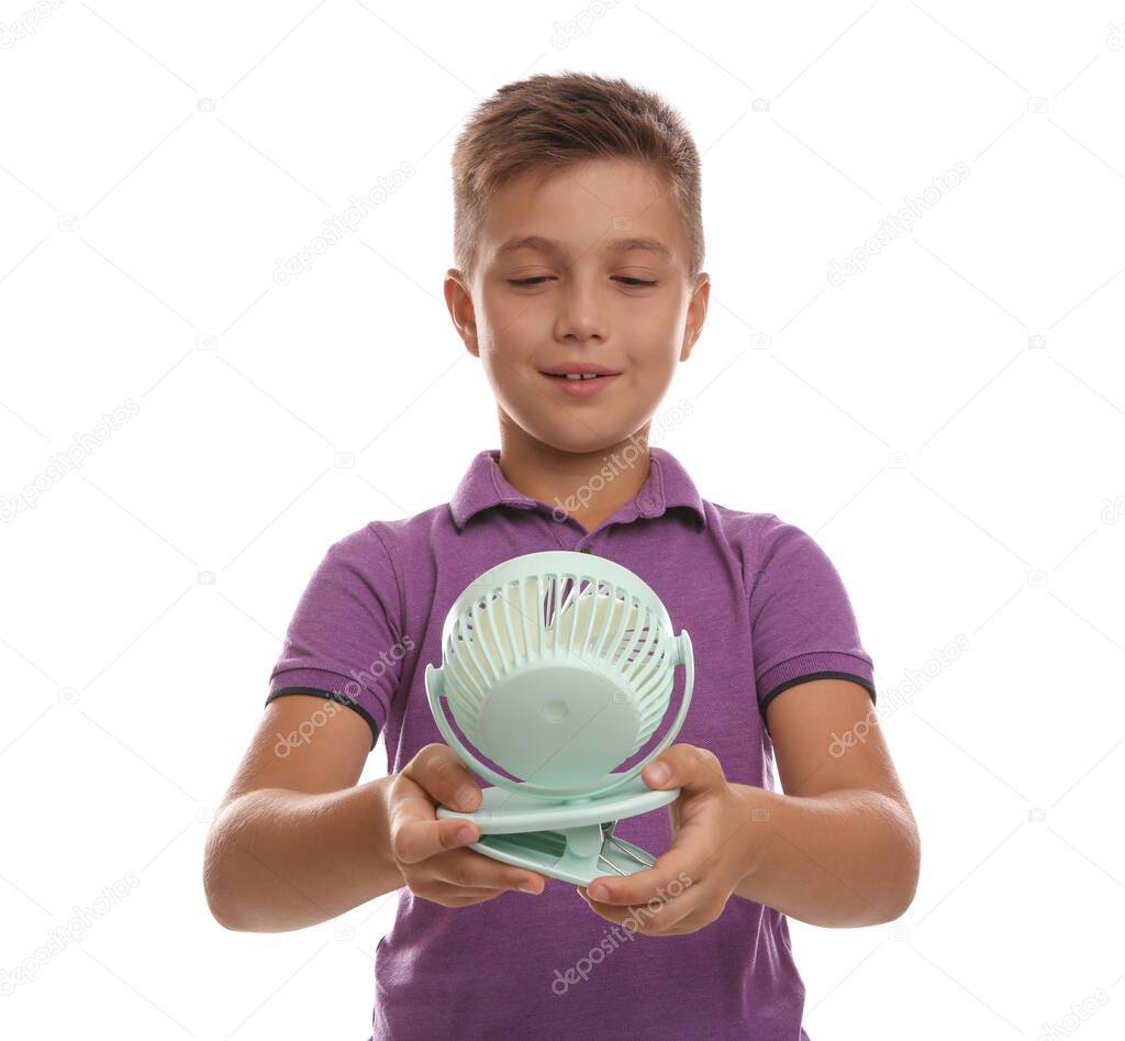 Little boy enjoying air flow from portable fan on white background. Summer heat