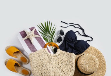 Beyaz arka planda şık plaj aksesuarları olan kompozisyon, üst görünüm