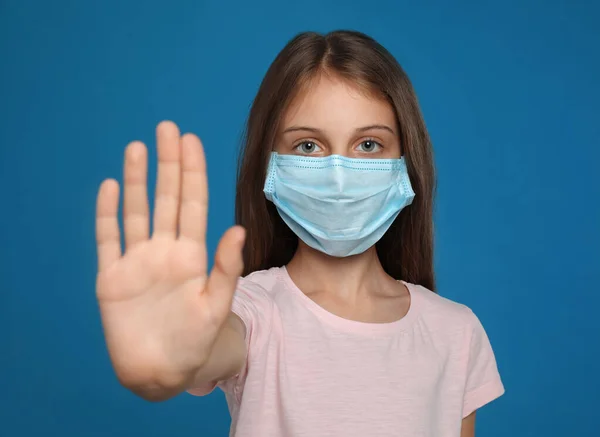 Menina Máscara Protetora Mostrando Parar Gesto Fundo Azul Prevenir Propagação — Fotografia de Stock