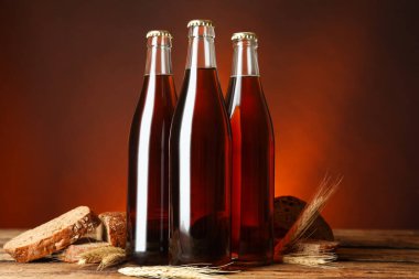 Lezzetli taze kvass şişeleri, çiviler ve ahşap masada ekmek.