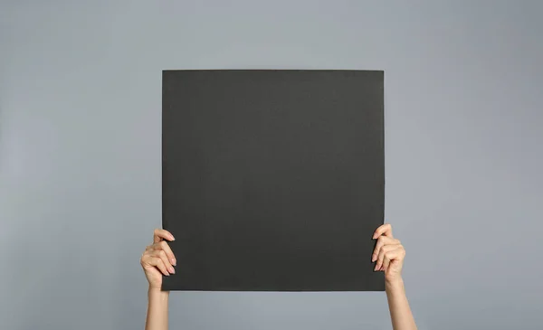 Gri Arka Planda Siyah Boş Poster Tutan Kadın Yakın Plan — Stok fotoğraf