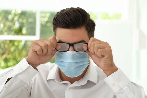 Hombre Limpiando Gafas Niebla Causada Por Uso Máscara Médica Interior — Foto de Stock