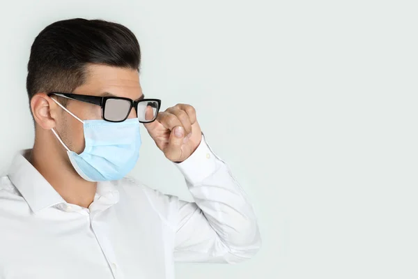 Uomo Pulire Vetri Nebbiosi Causati Indossare Maschera Medica Sfondo Chiaro — Foto Stock