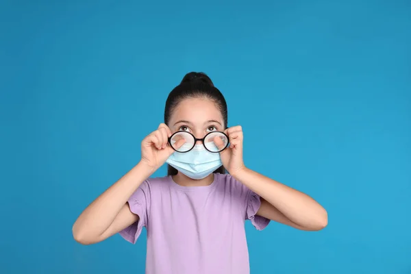 Mała Dziewczynka Wycierająca Mgliste Okulary Spowodowane Przez Noszenie Medycznej Maski — Zdjęcie stockowe