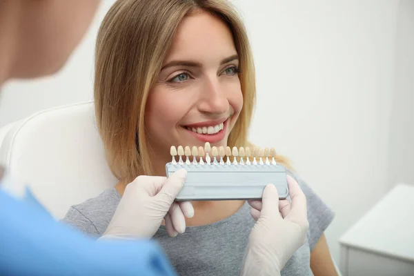 医者は患者の歯の色を診療所のパレットと一致させる 化粧品歯科 — ストック写真
