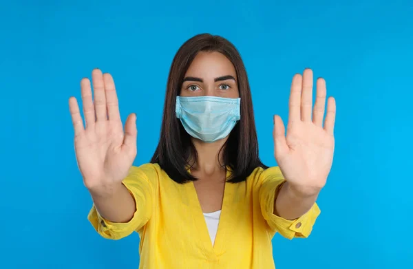 Jovem Mulher Máscara Protetora Mostrando Parar Gesto Fundo Azul Claro — Fotografia de Stock