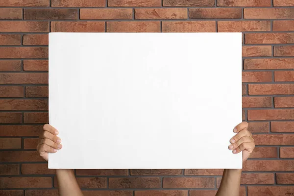 Man Holding White Blank Poster Red Brick Wall Closeup Mockup — Stock Photo, Image