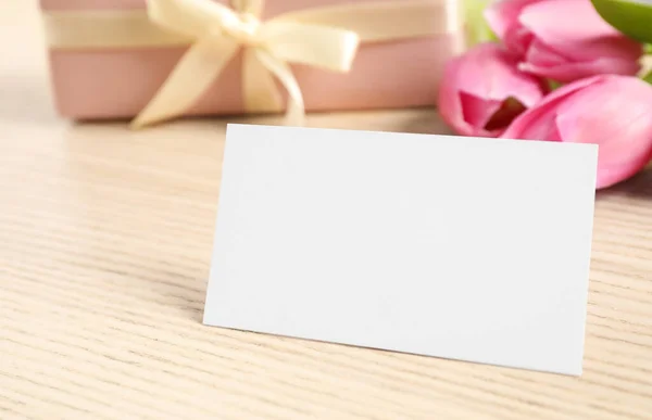 空白卡片 上面有文字 漂亮的郁金香和木制桌子上的礼物 — 图库照片