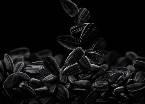 Sonnenblumenkerne Fallen Auf Haufen Auf Schwarzem Hintergrund — Stockfoto