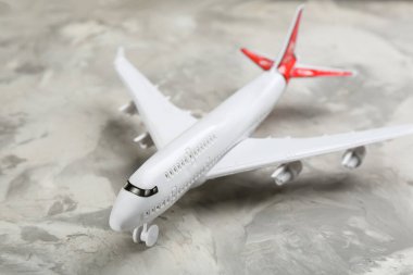 Gri arka planda oyuncak uçak, yakın plan. Seyahat kavramı