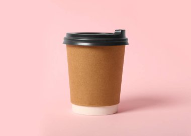 Pembe arka planda paket kağıttan kahve fincanı.