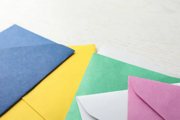 Красочные Бумажные Конверты Белом Деревянном Фоне Крупным Планом — стоковое фото
