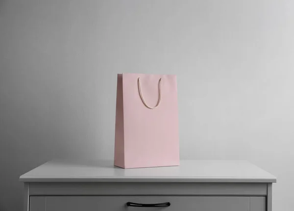 Bolso Compras Papel Sobre Cómoda Blanca Contra Fondo Claro — Foto de Stock