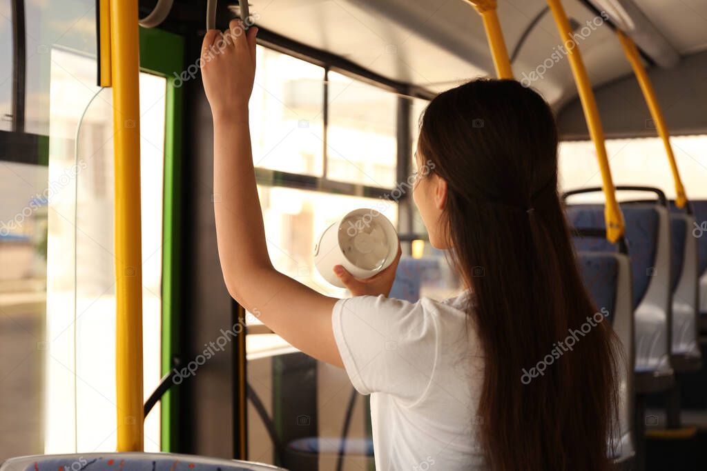 Woman with portable fan in bus. Summer heat