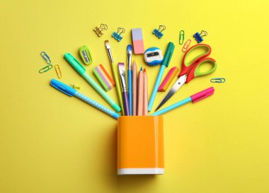 Düz kompozisyon ve sarı arka planda okul kağıtları. Okula geri dön.