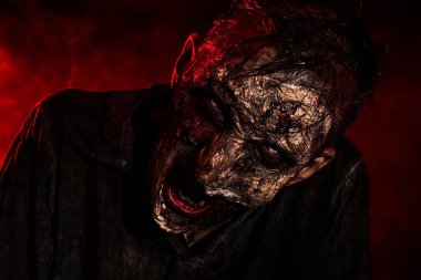 Karanlık arka planda korkunç bir zombi, yakın plan. Cadılar Bayramı canavarı