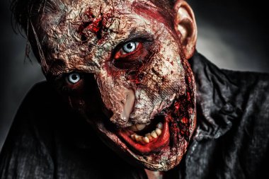 Karanlık arka planda korkunç bir zombi, yakın plan. Cadılar Bayramı canavarı