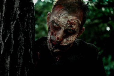 Ağacın yanındaki korkunç zombi. Cadılar Bayramı canavarı