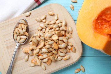 Çiğ tohumlar ve açık mavi ahşap masa üzerinde taze balkabağı, düz yatıyordu