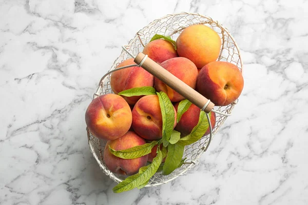 Fresh Sweet Peaches Metal Basket White Marble Table Top View — Stock Photo, Image