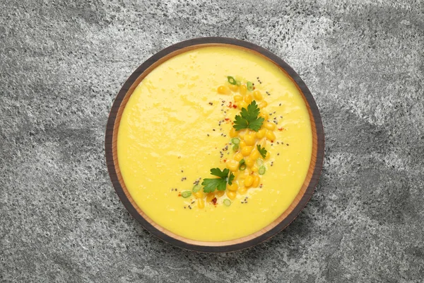 Delicious creamy corn soup on grey table, top view