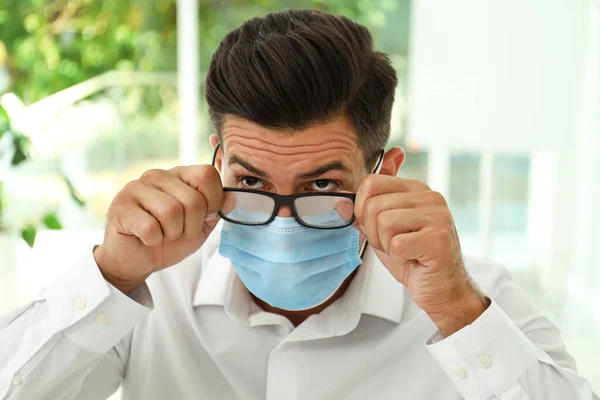 Homem Limpando Óculos Nebulosos Causados Pelo Uso Máscara Médica Dentro — Fotografia de Stock