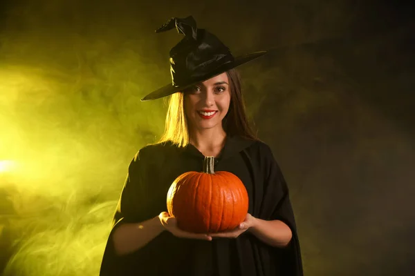 Egy Fiatal Boszorkányjelmezt Visel Tökkel Füstfelhőben Sötét Háttérben Halloween Buli — Stock Fotó