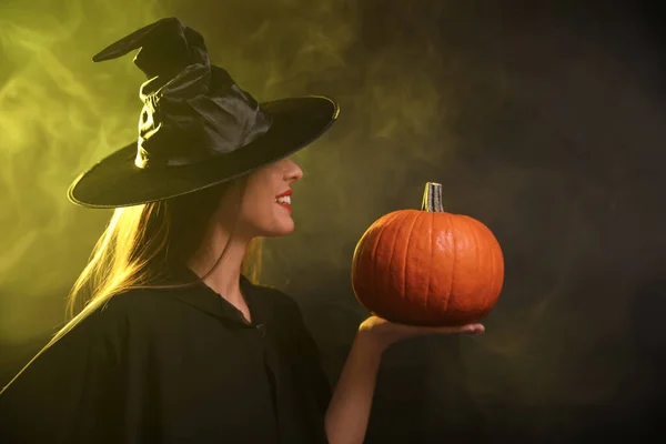 Egy Fiatal Boszorkányjelmezt Visel Tökkel Füstfelhőben Sötét Háttérben Halloween Buli — Stock Fotó