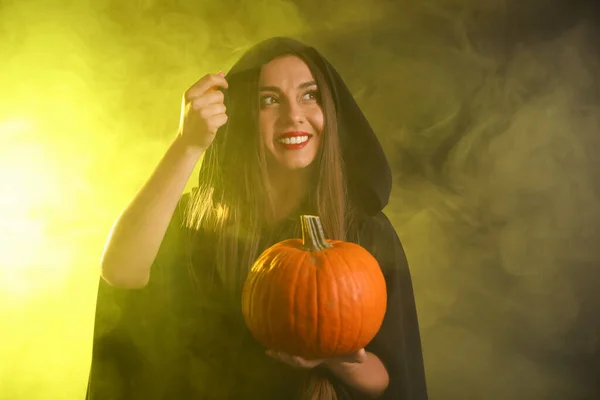 Egy Fiatal Boszorkányjelmezt Visel Tökkel Füstfelhőben Sötét Háttérben Halloween Buli — Stock Fotó