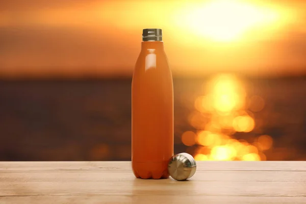 Botella Termo Sobre Mesa Madera Cerca Del Mar Atardecer — Foto de Stock