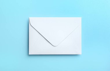 Açık mavi zemin üzerinde beyaz kağıt zarf, üst görünüm
