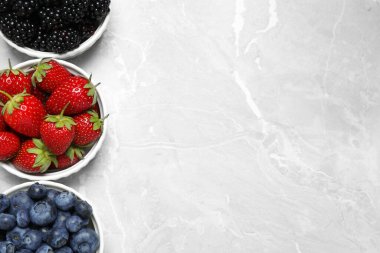 Aydınlık mermer masada farklı olgun böğürtlenler var, düz yerde. Metin için boşluk