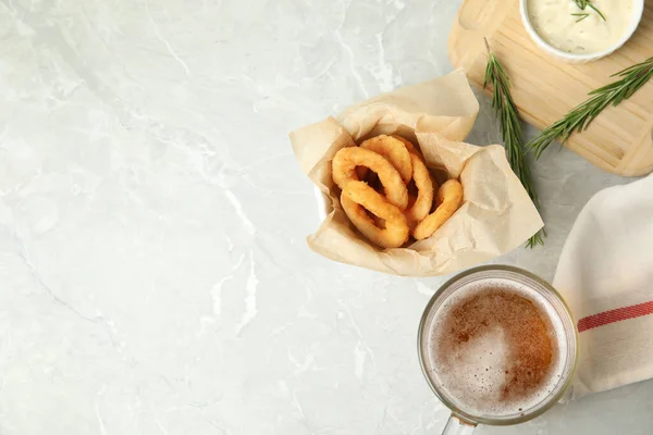 美味的脆炸洋葱圈和一杯啤酒放在灰色大理石桌上 案文的篇幅 — 图库照片