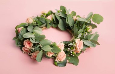 Pembe arka planda güzel çiçeklerden yapılmış çelenk