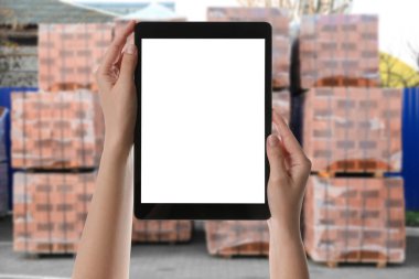 Toptan alım satım. Depodaki tablette WMS uygulaması kullanan bir kadın. 