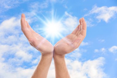 Parlak ışık ellerinde, yakın çekim. Güneş enerjisi kavramı