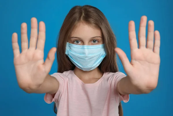 Menina Máscara Protetora Mostrando Parar Gesto Fundo Azul Prevenir Propagação — Fotografia de Stock