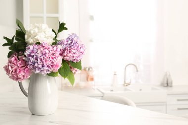 Bouquet with beautiful hydrangea flowers on white marble table. Space for text clipart