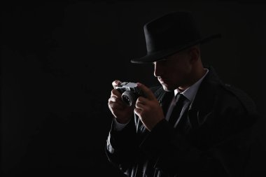Karanlık arka planda kamera olan eski moda dedektif. Metin için boşluk