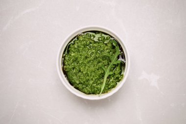 Bir kase lezzetli roka pesto Işık masasında, üst manzara