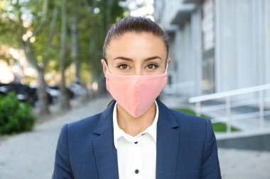 Dışarıda el yapımı kumaş maskeli bir kadın. COVID-19 salgını sırasında kişisel koruma ekipmanları