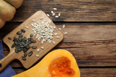 Çiğ tohumlar ve ahşap masada taze kabaklar, düz uzanmış. Metin için boşluk