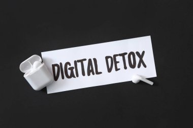 Siyah arkaplan üzerinde dijital detoks ve kulaklık olan kağıt not, düz yatıyordu