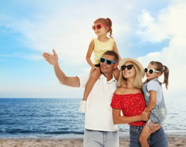 Happy family resting near sea on sunny day. Summer vacation clipart