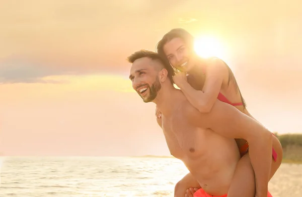 快乐的年轻夫妇在阳光明媚的海滩上玩得很开心 — 图库照片