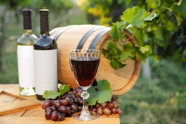 ブドウ畑の木のテーブルの上にワインと熟したブドウとの組成 — ストック写真