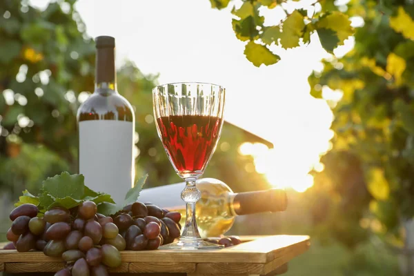 ブドウ畑の木のテーブルの上にワインと熟したブドウとの組成 — ストック写真