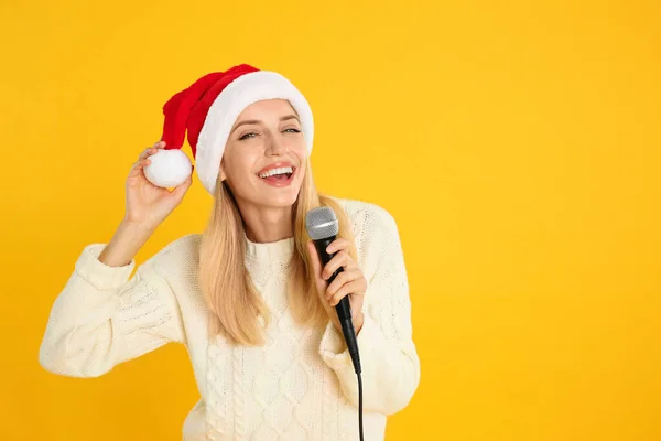 Emocjonalna Kobieta Kapeluszu Świętego Mikołaja Śpiewająca Mikrofonem Żółtym Tle Miejsce — Zdjęcie stockowe