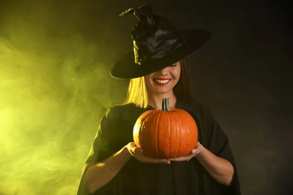 Egy Fiatal Boszorkányjelmezt Visel Tökkel Füstfelhőben Sötét Háttérben Halloween Buli — Stock Fotó