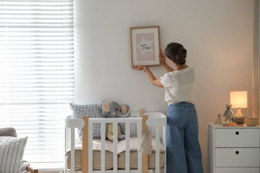 Bebek odasının duvarına asılı bir dekoratör resmi. İç tasarım